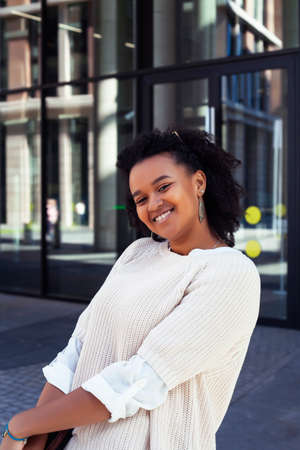 young cheerful african girl posing cheerful on city background, lifestyle outdoor people concept