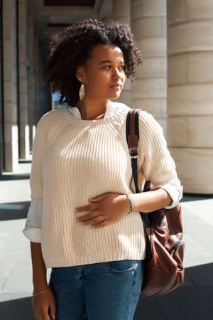 young pretty african girl posing cheerful on city background, lifestyle outdoor people concept