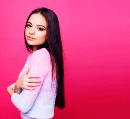 young cute girl on pink background smiling adorable emotional posing, lifestyle people concept