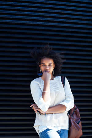 young pretty african girl posing cheerful on city background, lifestyle outdoor people conceptの写真素材