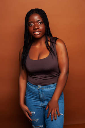 pretty young african american woman posing cheerful gesturing on brown background, lifestyle people conceptの写真素材