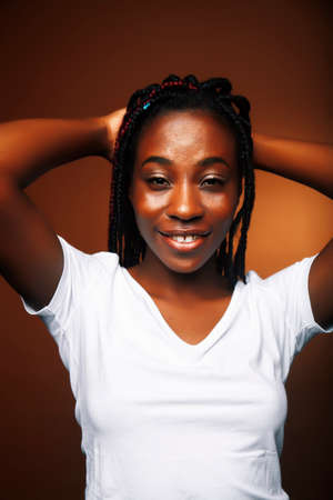 pretty young african american woman posing cheerful gesturing on brown background, lifestyle people...