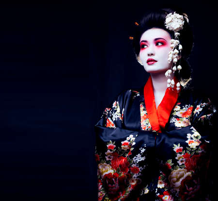 young pretty real geisha in kimono with sakura and decorationの写真素材