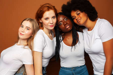 young pretty asian, caucasian, afro woman posing cheerful together on brown background, lifestyle diverse nationality people conceptの写真素材