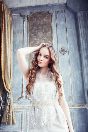 young pretty lady girl posing sexy in vintage hotel bedroom interior, lifestyle rich people conceptの写真素材