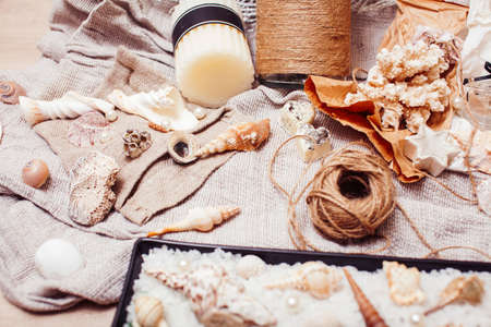 a lot of sea theme in mess like shells, candles, perfume, girl stuff on linen, pretty textured post card view vintageの写真素材