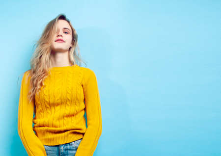 young pretty teenage modern hipster girl posing emotional happy on blue background, lifestyle people conceptの写真素材