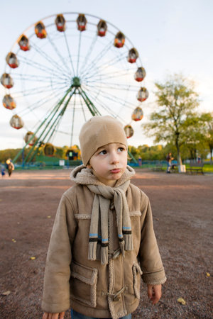 little cute real boy on bicycle emotional smiling close up outside in green amusement parkの写真素材