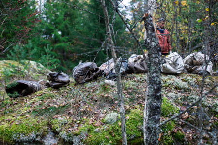 big amount of trash in forest, family father and son picking garbage away, global environment issues
