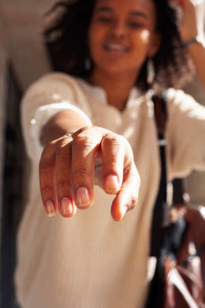 young pretty african girl posing cheerful on city background, lifestyle outdoor people conceptの写真素材