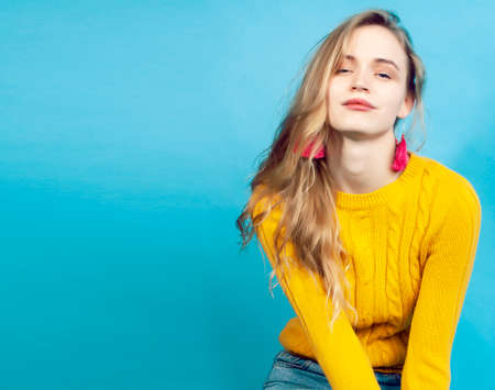 young pretty teenage modern hipster girl posing emotional happy on blue background, lifestyle people conceptの写真素材