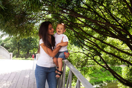 young pretty brunette mother with little cute boy walking in park happy smiling, lifestyle people...
