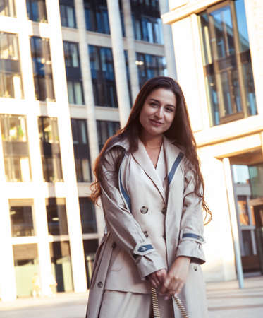 young pretty brunette woman in fashion suit at business building posing cheerful, lifestyle people conceptの写真素材