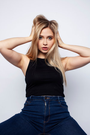 young blond woman on white backgroung gesture thumbs up, isolated emotional posingの写真素材