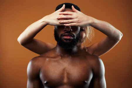 Young pretty couple diverse races together posing sensitive on brown background, lifestyle people conceptの写真素材