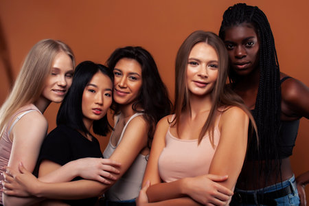 young pretty asian, caucasian, afro woman posing cheerful together on brown background, lifestyle diverse nationality people conceptの写真素材