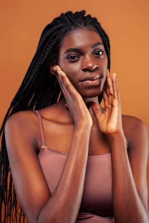 pretty young african american woman posing cheerful gesturing on brown background, lifestyle people conceptの写真素材