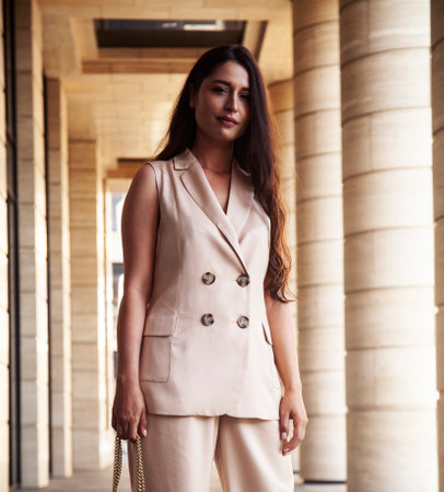 young pretty brunette woman in fashion suit at business building posing cheerful, lifestyle people conceptの写真素材
