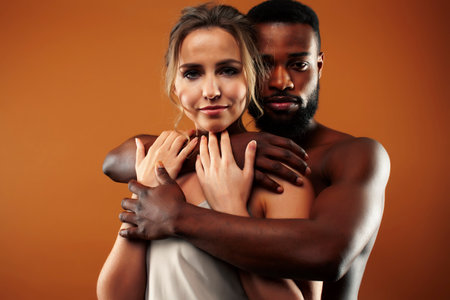 Young pretty couple diverse races together posing sensitive on brown background, lifestyle people conceptの写真素材