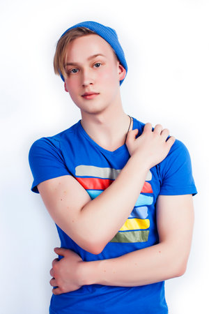 young handsome teenage hipster guy in hat posing emotional, happy smiling against white background...
