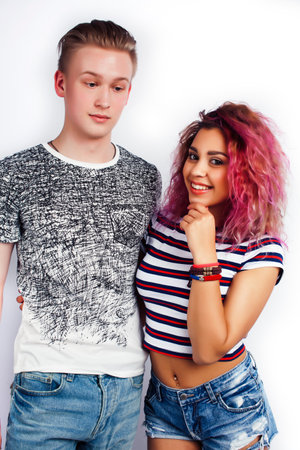 young pretty teenage couple, hipster blond guy with his mixed raced girlfriend happy smiling and...