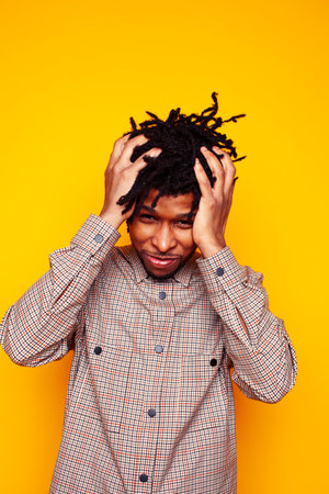 young handsome african american guy student posing cheerful and gesturing on yellow background, lifestyle people conceptの写真素材