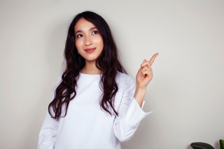 young asian woman doctor in white uniform gesturing positive on gray background, lifestyle healthcare people conceptの写真素材