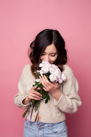 young pretty girl with curly hair posing cheerful on pink background, lifestyle people conceptの写真素材