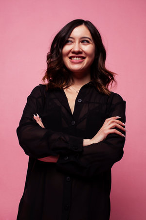 young pretty girl with curly hair posing cheerful on pink background, lifestyle people concept