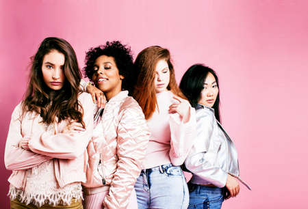 different nation girls with diversuty in skin, hair. Asian, scandinavian, african american cheerful emotional posing on pink background, woman day celebration, lifestyle people conceptの写真素材