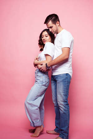 young cheerful caucasian couple together having fun on pink background, guy ang girl modern relationship, lifestyle people conceptの写真素材