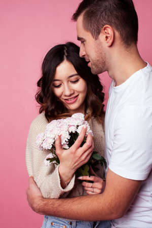 young cheerful caucasian couple together having fun on pink background, guy ang girl modern relationship, lifestyle people conceptの写真素材
