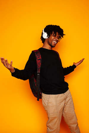 young handsome african american guy student posing cheerful and gesturing on yellow background, lifestyle people conceptの写真素材