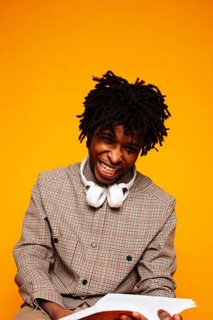 young handsome african american guy student posing cheerful and gesturing on yellow background, lifestyle people conceptの写真素材