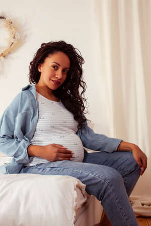 young pretty african american woman pregnant laying in bed, lifestyle people conceptの写真素材
