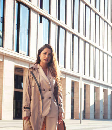 young pretty brunette woman in fashion suit at business building posing cheerful, lifestyle people conceptの写真素材