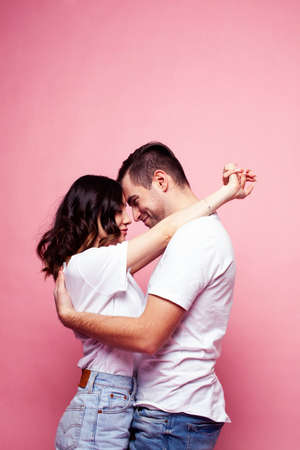 young cheerful caucasian couple together having fun on pink background, guy ang girl modern relationship, lifestyle people conceptの写真素材