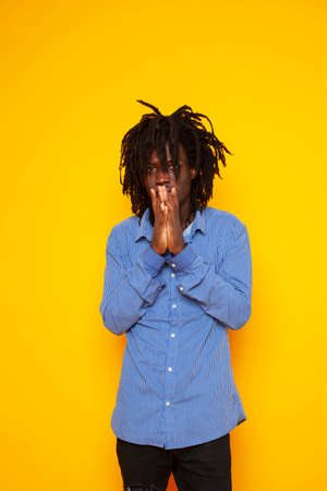 young handsome african american guy student posing cheerful and gesturing on yellow background, lifestyle people conceptの写真素材