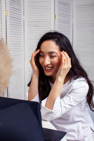 young pretty asian woman in white form working in clinic with laptop, lifestyle working people...