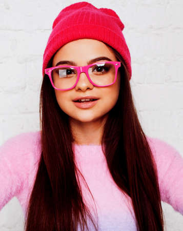 pretty young teenage girl hipster in pink glasses and hat emotional posing happy smiling, lifestyle people conceptの写真素材