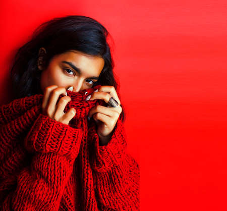 young pretty indian girl in red sweater posing emotional, fashion hipster teenage, lifestyle people conceptの写真素材