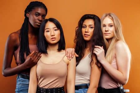 young pretty asian, caucasian, afro woman posing cheerful together on brown background, lifestyle diverse nationality people conceptの写真素材