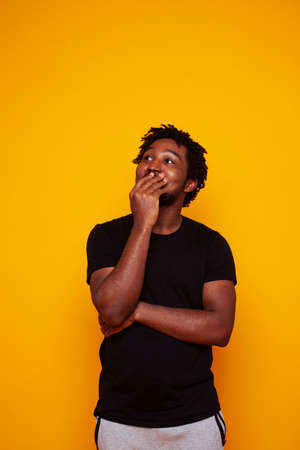 young handsome african american guy student posing cheerful and gesturing on yellow background, lifestyle people conceptの写真素材