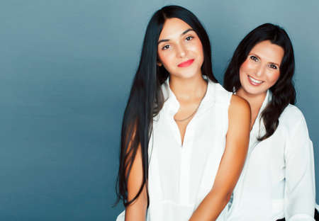 cute pretty teen daughter with mature mother hugging, fashion style brunette, lifestyle people conceptの写真素材