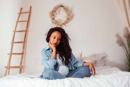 young pretty african american woman pregnant laying in bed, lifestyle people conceptの写真素材