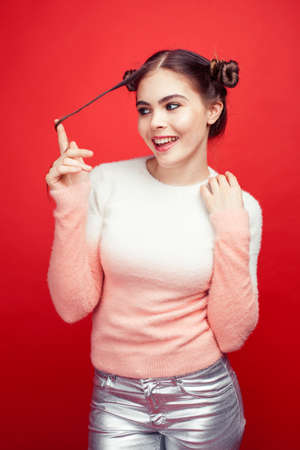 young pretty posing teenage girl on bright red background, happy smiling lifestyle people concept