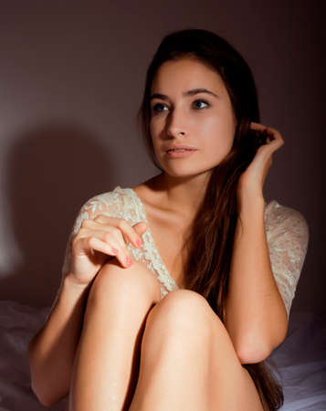 young pretty happy smiling sexy woman in her bed bedroom at night, lifestyle people conceptの写真素材