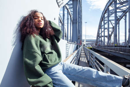 young cute teenage african girl in industrial zone happy smiling having fun, big city lifestyle fashion peopleの写真素材