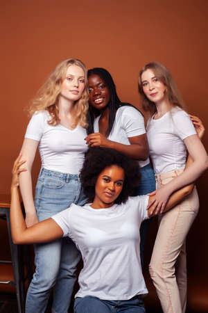 young pretty caucasian, afro, scandinavian woman posing cheerful together on brown background, lifestyle diverse nationality people conceptの写真素材