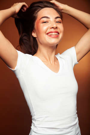 young pretty asian woman cheerful smiling posing on warm brown background, lifestyle people conceptの写真素材